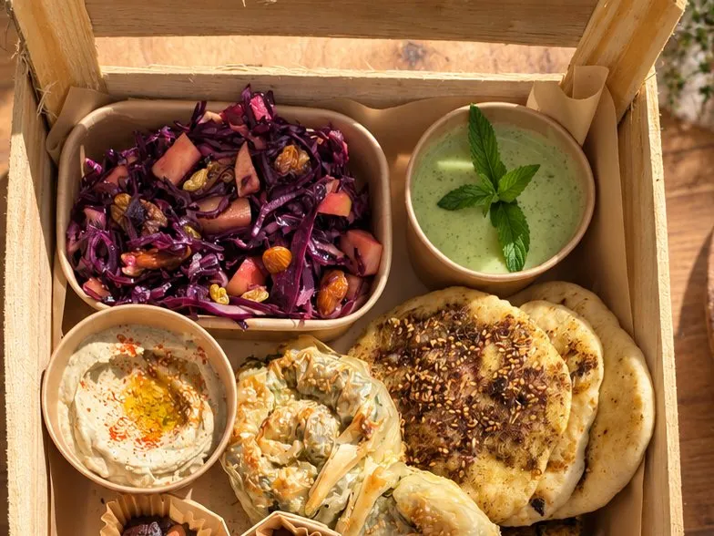 Salade de chou rouge, houmous, soupe verte et pains farcis dans la cagette